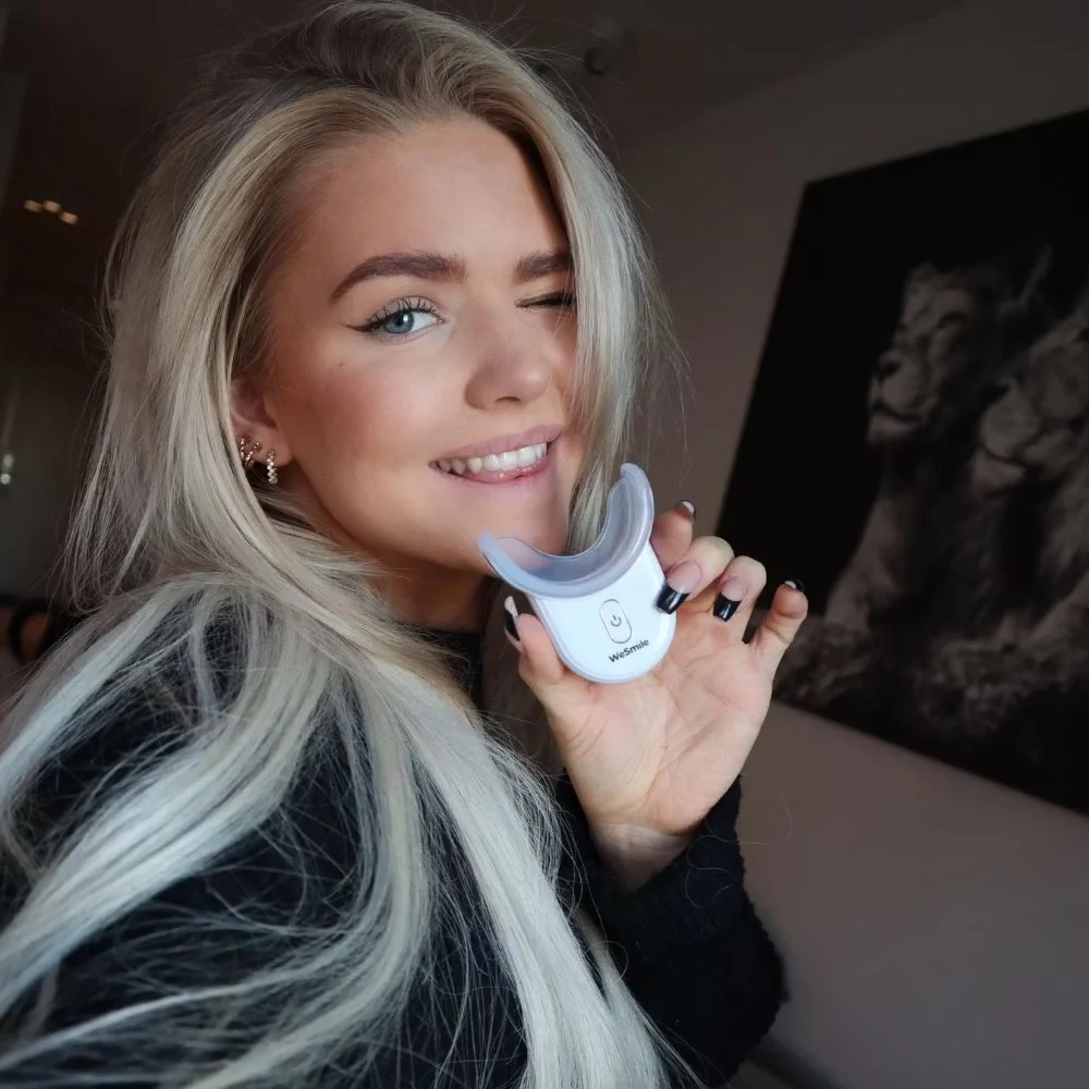 Holder LED-boosteren med skinnen op mod sit smil