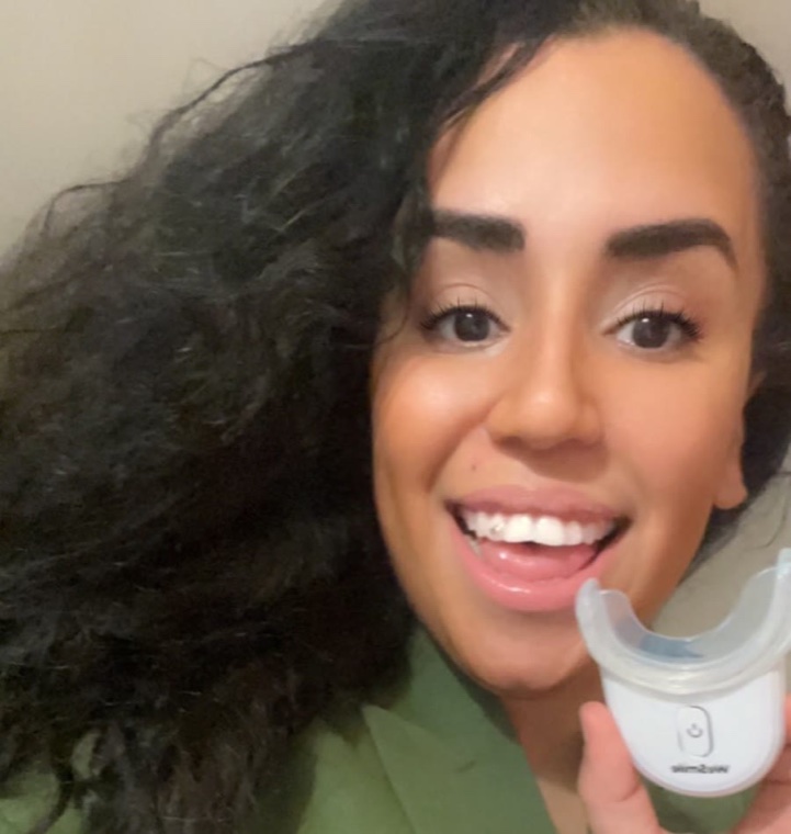 Mohiba Talhaoui smiler og holder WeSmiles LED-skinne op
